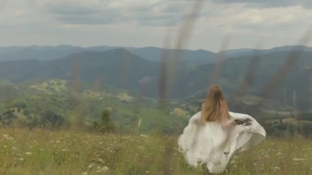 Hermosa novia en vestido de novia corriendo a través de las montañas colinas — Vídeo de stock