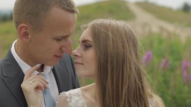 Damat ve gelin birlikte çiçek bir glade üzerinde. Düğün çifti. Mutlu aile