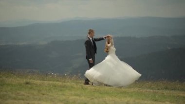 Damat gelin ile bir dağ tepelerinde eğleniyor. Düğün. Gelin dans ediyor
