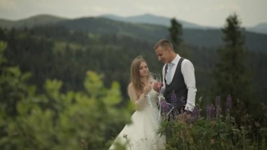 Gelinli damat dağ tepelerinde şampanya içer. Düğün çifti. Aile