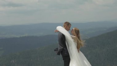 Damat gelin ile bir dağ tepelerinde eğleniyor. Düğün çift sarılma