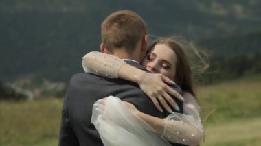 Damat gelin ile bir dağ tepelerinde eğleniyor. Düğün çift sarılma