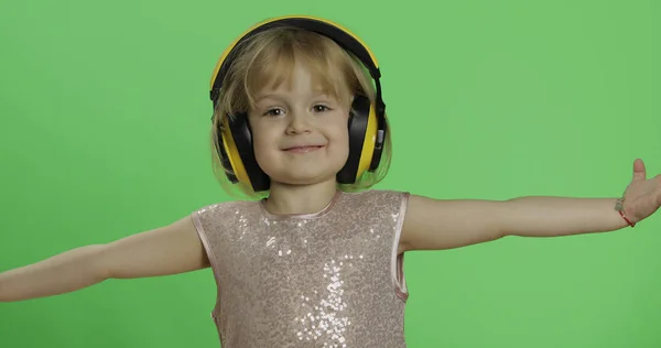 Girl in glossy dress and headphone listening to music and dancing. Chroma Key