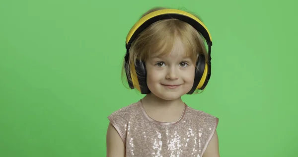 Chica en vestido brillante y auriculares escuchando música. Clave de croma — Foto de Stock