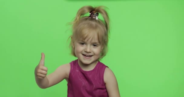 Chica en vestido púrpura muestran los pulgares hacia arriba. Feliz niña de cuatro años. Clave de croma — Vídeos de Stock