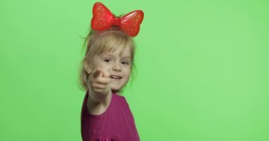 Mor elbiseli kız dans ediyor ve parmağını öne doğru gösteriyor. Mutlu çocuk. Renk Anahtarı