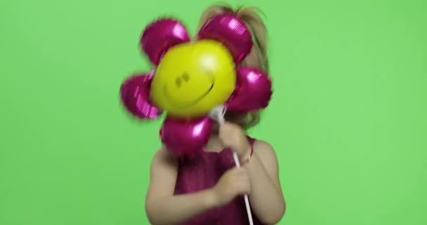 Chica sostiene globo en forma de flor. Feliz niña de cuatro años. Clave de croma — Vídeos de Stock