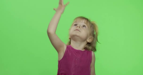紫色のドレスを着た女の子が踊り、手で手を振る。幸せな子供だクロマキー — ストック動画