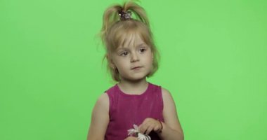 Kız papatya çiçek tutar ve bir şey söyler. Mutlu küçük çocuk. Renk Anahtarı