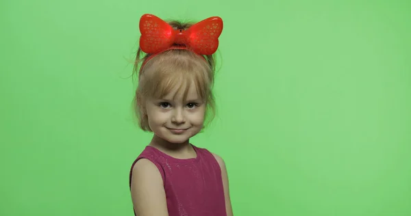 Positives Mädchen in lila Kleid und roter Schleife, das in die Kamera blickt. Chroma-Schlüssel — Stockfoto