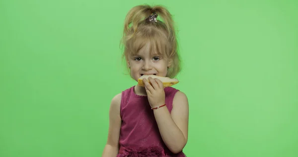 Positieve blonde meisje in paarse jurk met een stukje meloen. Chroma Key — Stockfoto