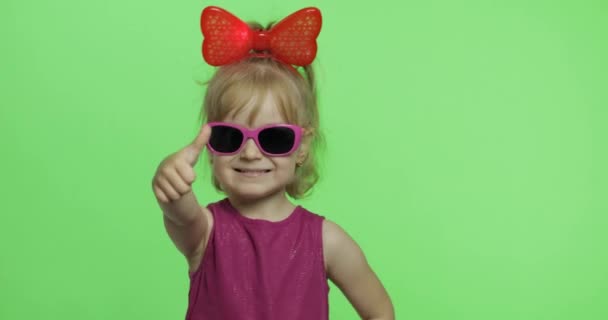 Chica en vestido morado, gafas de sol y cinta roja. Muestra los pulgares arriba. Clave de croma — Vídeos de Stock