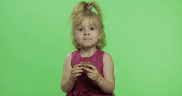 Dívka v purpurovém oblečení s čokoládovým vejcem. Šťastné čtyři roky staré dítě. Klíč Chroma — Stock fotografie