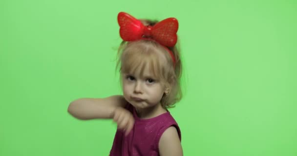 Chica en vestido morado bailando y muestra un dedo hacia adelante. Feliz niña. Clave de croma — Vídeo de stock