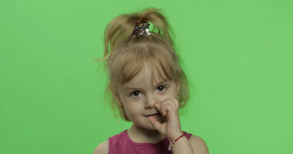 Dětský portrét v fialových šatech. Dívka si vybírá nos. Klíč Chroma — Stock fotografie