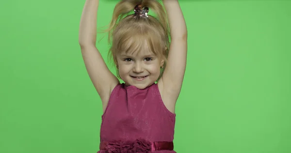 Positief meisje op zoek naar een camera in paarse jurk. Handen omhoog. Chroma Key — Stockfoto