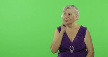 Yaşlı bir kadın bir şey düşünüyor. Eski düşünceli büyükanne. Chroma anahtarı