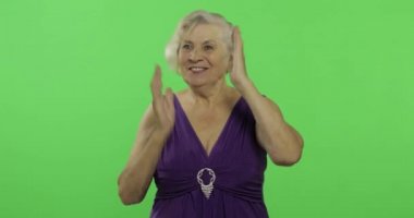Yaşlı bir kadın şaşırtması, sevinç ve gülümsüyor gösterir. Yaşlı büyükanne. Chroma anahtarı