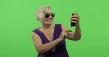 Yaşlı bir kadın bir smartphone bir fotoğraf yapmak. Selfie. Chroma anahtarı