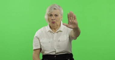 Yaşlı bir kadın bir stop jest gösterir. Yaşlı büyükanne. Chroma anahtarı