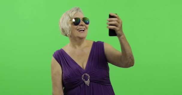 Uma mulher idosa faz uma foto em um smartphone. Selfie. Chave Chroma — Vídeo de Stock