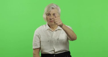 Yaşlı bir kadın başparmak yukarı göstermek ve gülümsüyor. Yaşlı büyükanne. Chroma anahtarı