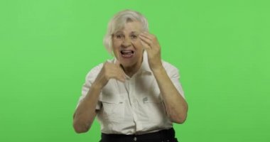 Yaşlı bir kadın ellerle bağırıp sallıyor. Yaşlı büyükanne gülümsüyor. Chroma anahtarı