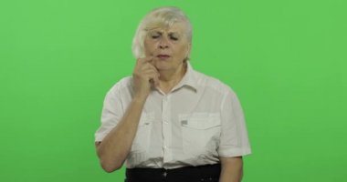 Yaşlı bir kadın baş ağrısı ağrı sorunu ile muzdarip. Yaşlı büyükanne. Chroma anahtarı