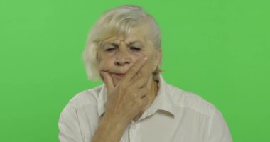 Yaşlı bir kadın bir şey düşünüyor. Eski düşünceli büyükanne. Chroma anahtarı