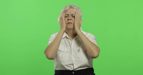 Uma mulher idosa sofre de dor de cabeça. Velha avó. Chave Chroma — Vídeo de Stock