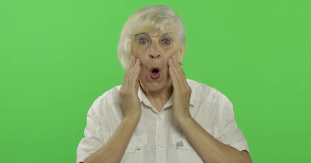An elderly woman shows amazement, surprise, joy and smiles. Chroma key — Stock Video