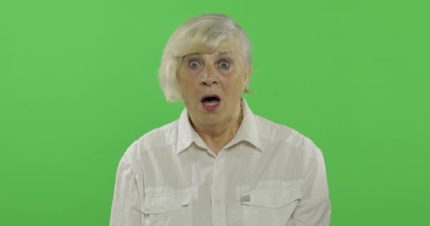 Yaşlı bir kadın şaşırtmak, sürpriz gösteriyor. Chroma anahtarı — Stok video