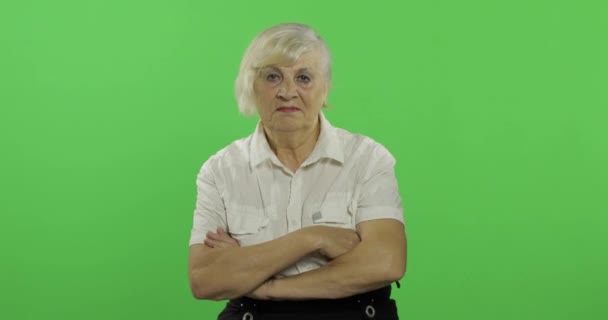 Een oudere vrouw met gekruiste armen. Kijkt naar de camera. Chroma Key — Stockvideo