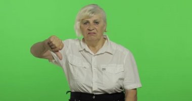 Yaşlı bir kadın, hayır ve başparmak aşağı vermek gösteren. Büyükanne. Chroma anahtarı