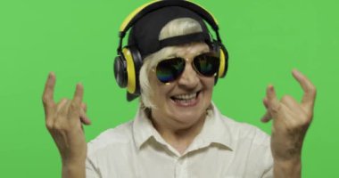 Yaşlı kadın kulaklıklar ve dans müzik dinler. Büyükanne. Chroma anahtarı