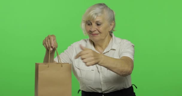 Μια ηλικιωμένη γυναίκα με τσάντα για ψώνια. Ψώνια. Παρουσιάζει. Πλήκτρο αποχρώσεων — Αρχείο Βίντεο