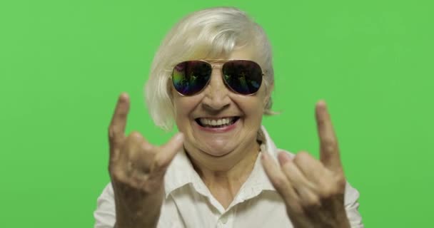 Eine ältere Frau zeigt mit ihren Händen Zeichen der Hörner. Chroma-Schlüssel — Stockvideo
