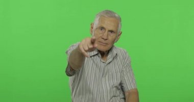 Kıdemli adam kameraya işaret ediyor. Chroma anahtar arka planda yakışıklı yaşlı adam