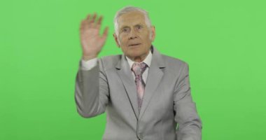 Yaşlı işadamı kameraya eller ile sallayarak. Resmi giyim yaşlı adam