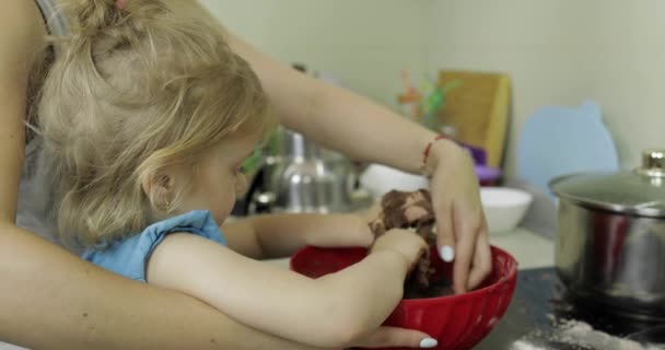 Moeder en dochter mengen chocolade deeg, meisje maken van taart in de keuken — Stockvideo