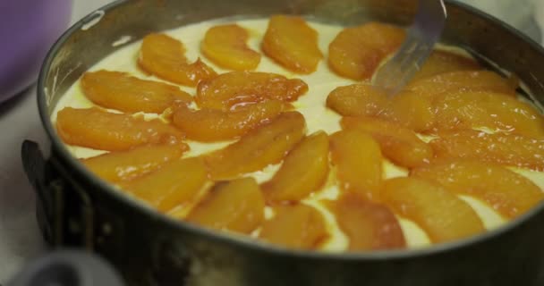 Het zetten van stukjes perziken op gemengde kwark en kippeneieren. Cheesecake — Stockvideo