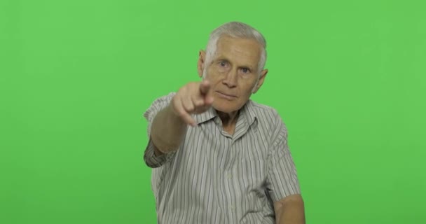 Starszy mężczyzna wskazuje na kamerę. Przystojny stary człowiek na Chroma klucz tło — Wideo stockowe
