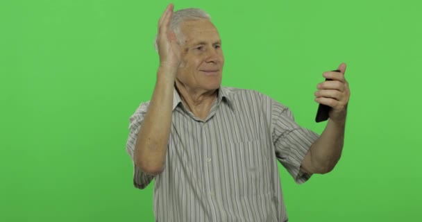老人在智能手机上说话。英俊的老人在色度关键背景 — 图库视频影像