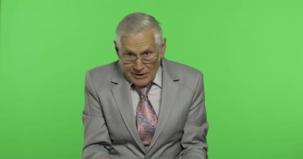 Oudere zakenman in pak iets emotioneel vertelt. Chroma Key-achtergrond — Stockvideo