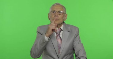 Sessizlik jest gösteren yaşlı işadamı. Yaşlı adam Shh jest gösteren