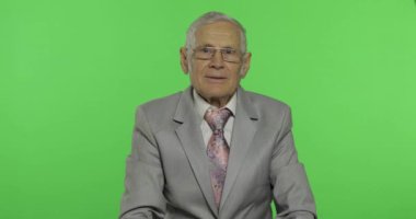 Yaşlı işadamı ok jest gösteren. Resmi giyim yaşlı adam iyi işareti vererek