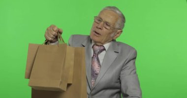 Alışveriş çantaları ile bored yaşlı adam. Alışveriş sonrası resmi giyim yaşlı adam