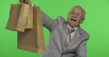 Alışveriş çantaları ile mutlu yaşlı adam. Alışveriş sonrası resmi giyim yaşlı adam