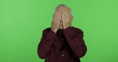 Kıdemli adam yüzünü elinde saklıyor ve casusluk yapıyor. Yakışıklı yaşlı adam. Chroma anahtarı