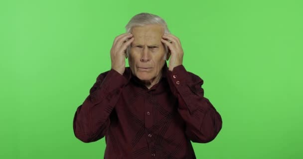 Senior man lijdt aan hoofdpijn pijn problemen. Knappe oude man op Chroma Key — Stockvideo